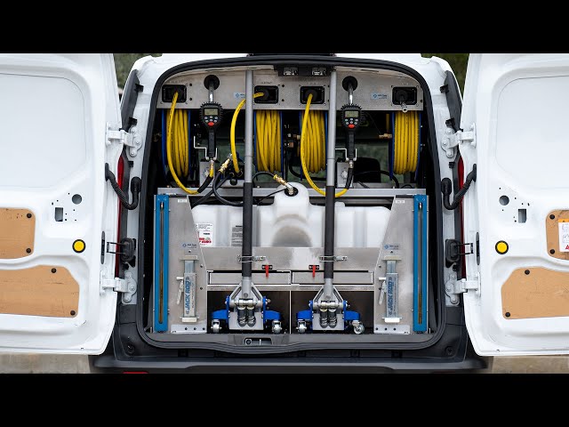 Inside the Oil To Go service van: metered hose reels, jacks, and oil tank, all neatly racked