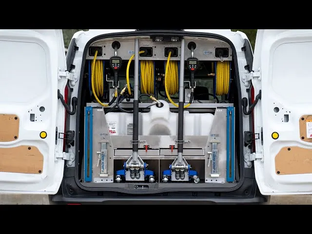 Inside the Oil To Go service van: metered hose reels, jacks, and oil tank, all neatly racked
